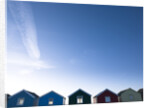 Beach huts in a row against blue skies by Assaf Frank